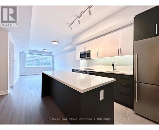 A modern kitchen with a large island and stainless steel appliances.