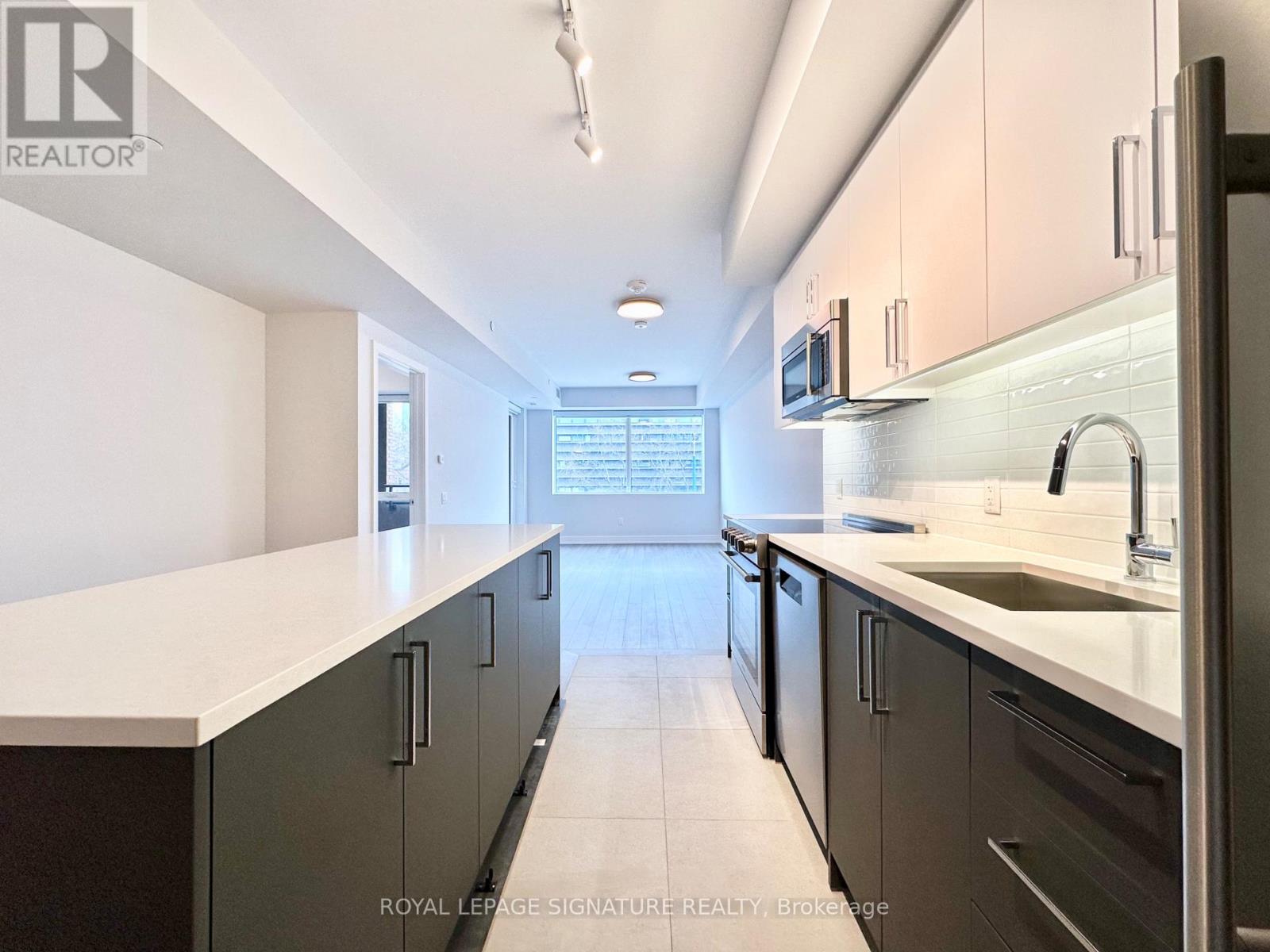A kitchen with a white counter top and black cabinets.