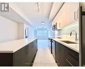 A kitchen with a white counter top and black cabinets.