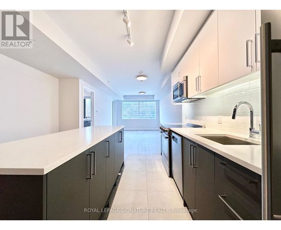 A kitchen with a white counter top and black cabinets.