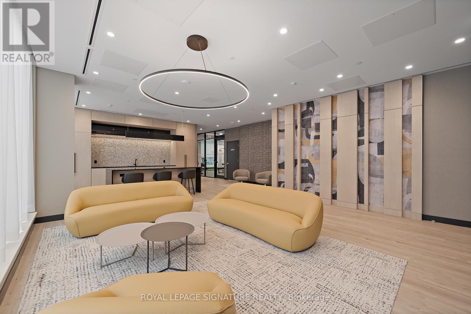 A living room with a yellow sofa and a circular light fixture on the ceiling.