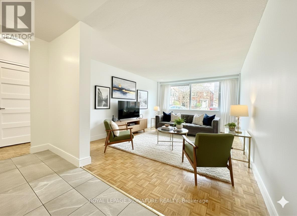 A living room with a couch, chairs, and a rug.