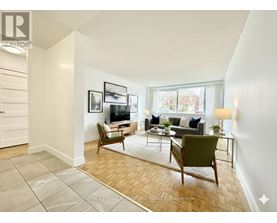 A living room with a couch, chairs, and a rug.