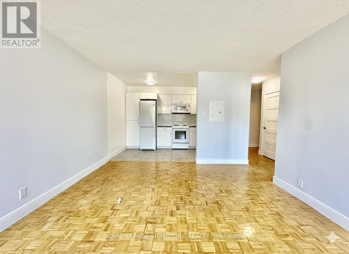 A kitchen area with a refrigerator, microwave, and oven.