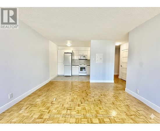 A kitchen area with a refrigerator, microwave, and oven.