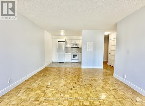 A kitchen area with a refrigerator, microwave, and oven.