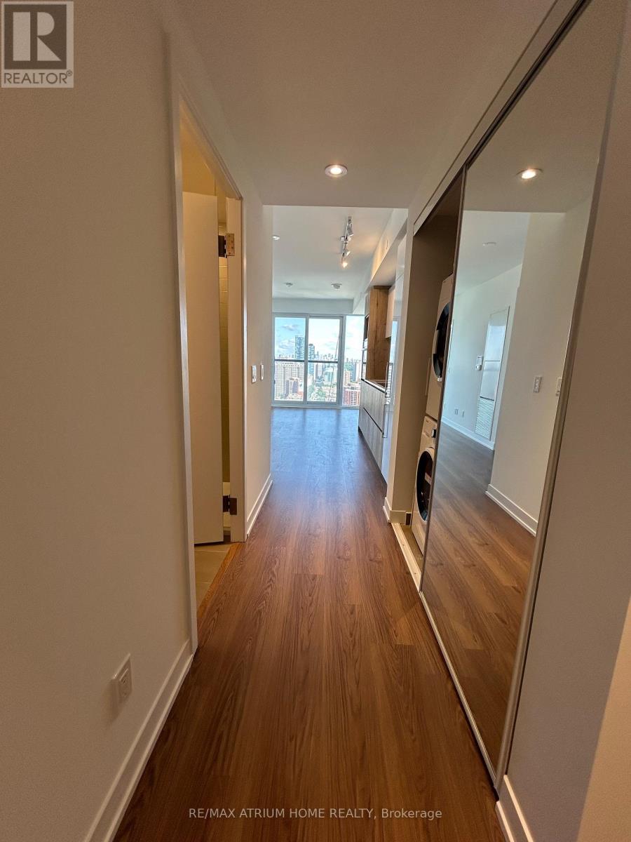 A long hallway with wood floors and white walls.