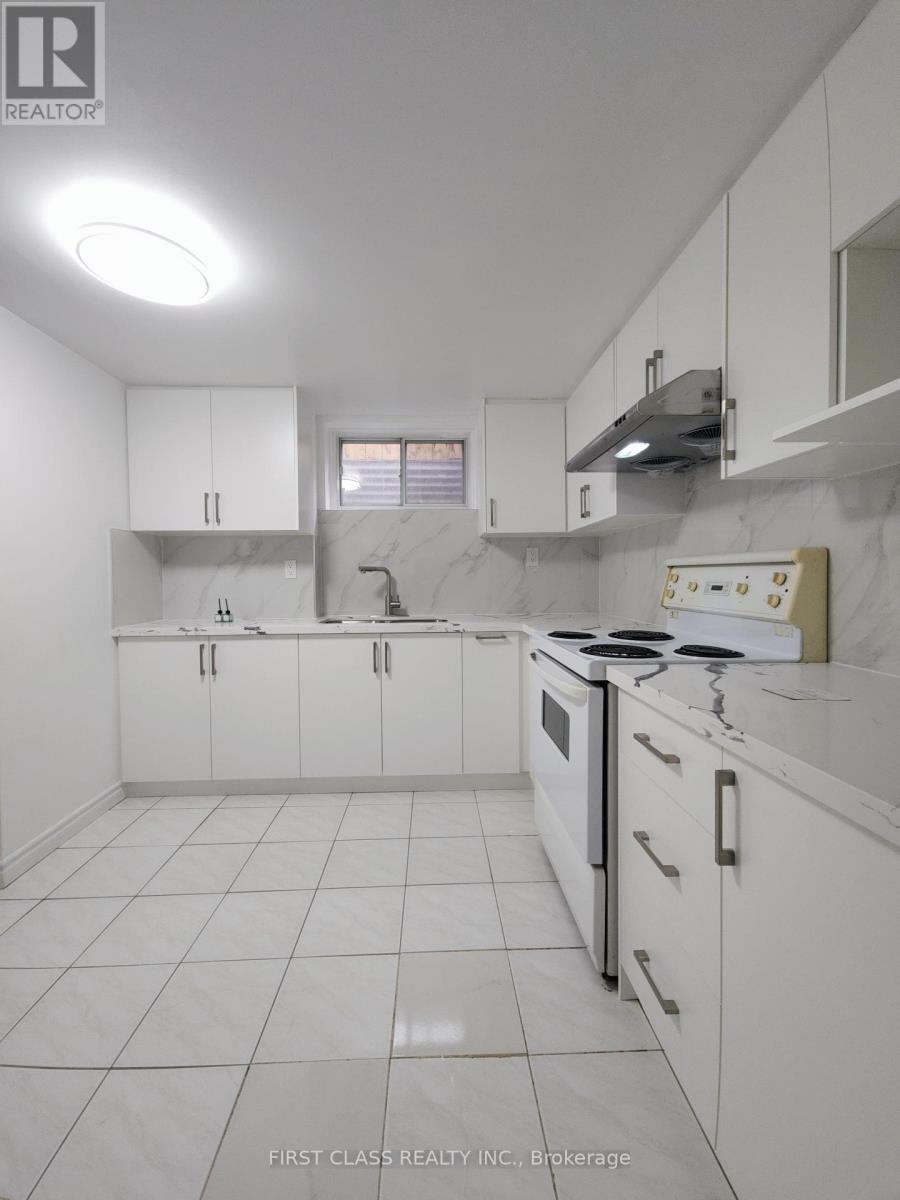 A white kitchen with a stove top oven and a range hood.
