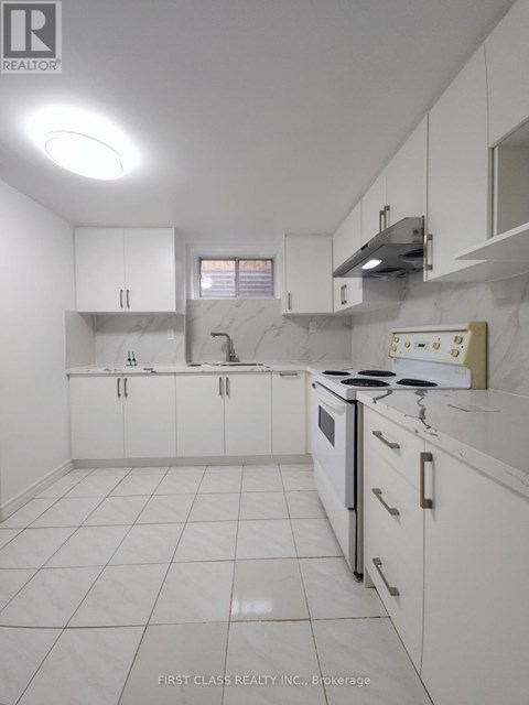 A white kitchen with a stove top oven and a range hood.