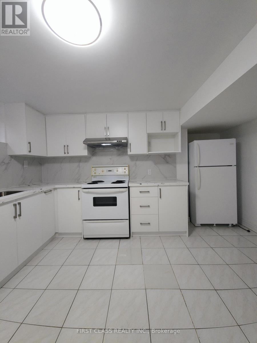 A white kitchen with a stove, oven, and refrigerator.