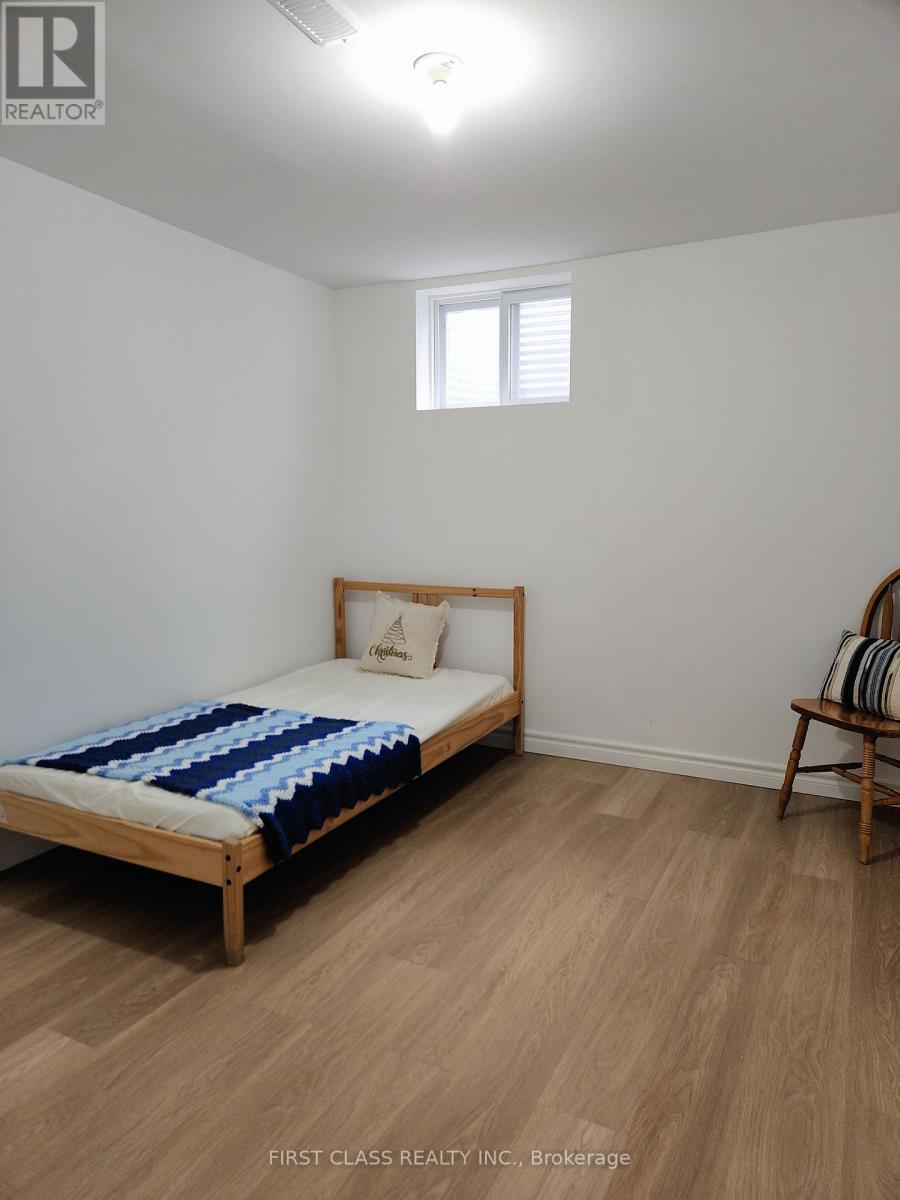 A bedroom with a bed, a chair, and a window.