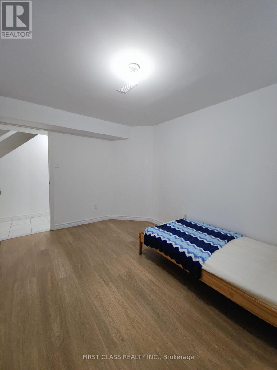 A bedroom with a bed and wooden floors.