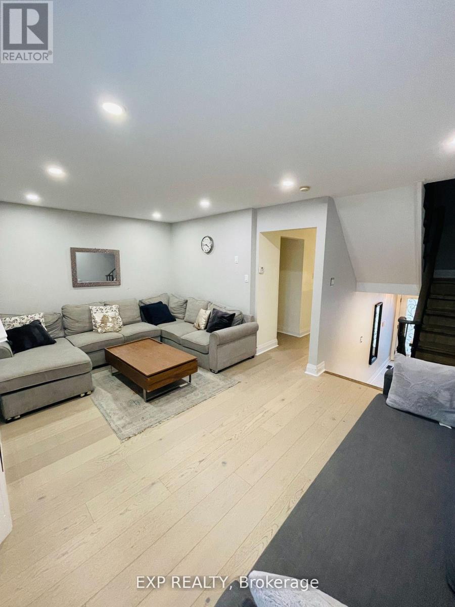 A spacious living room with a grey sofa set and a wooden coffee table.