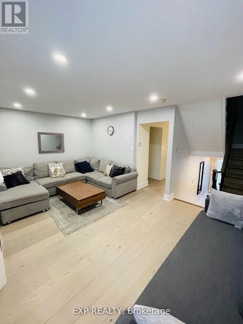 A spacious living room with a grey sofa set and a wooden coffee table.