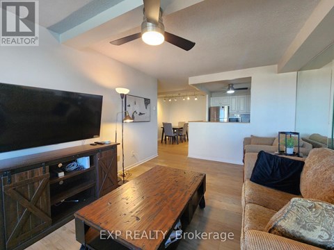 A living room with a wooden table and a flat screen TV.