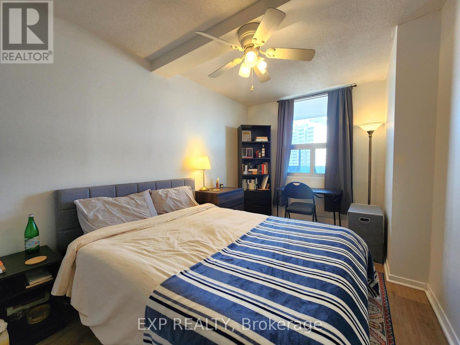 A bedroom with a large bed and a ceiling fan.