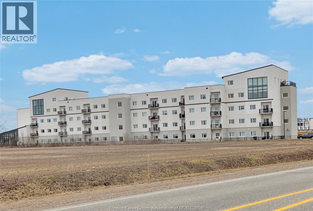 A large white apartment building with a REALTOR® logo in the corner.