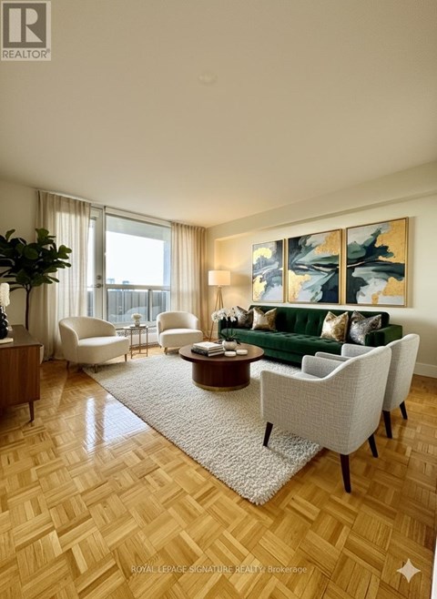 A living room with a green couch and a painting on the wall.