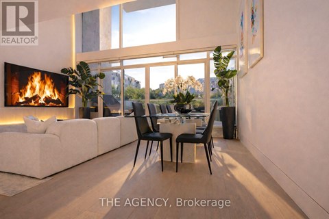 A modern living room with a fireplace and a dining table set up.