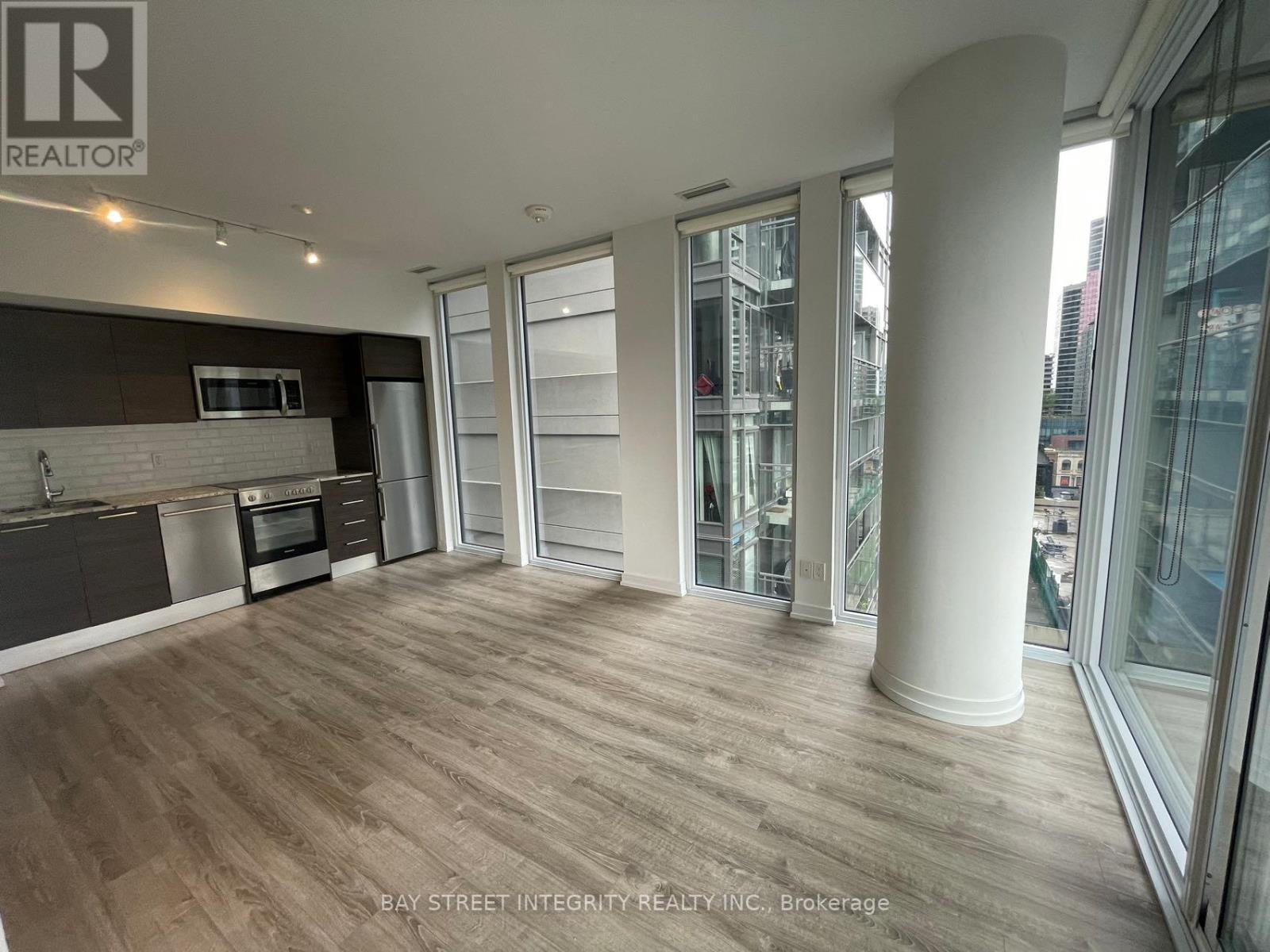 A spacious kitchen with wooden flooring and a large island.