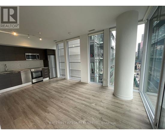 A spacious kitchen with wooden flooring and a large island.