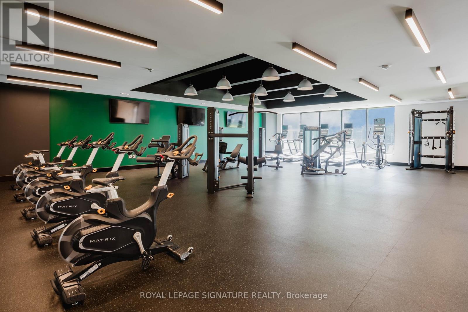 A gym with a row of stationary bikes.