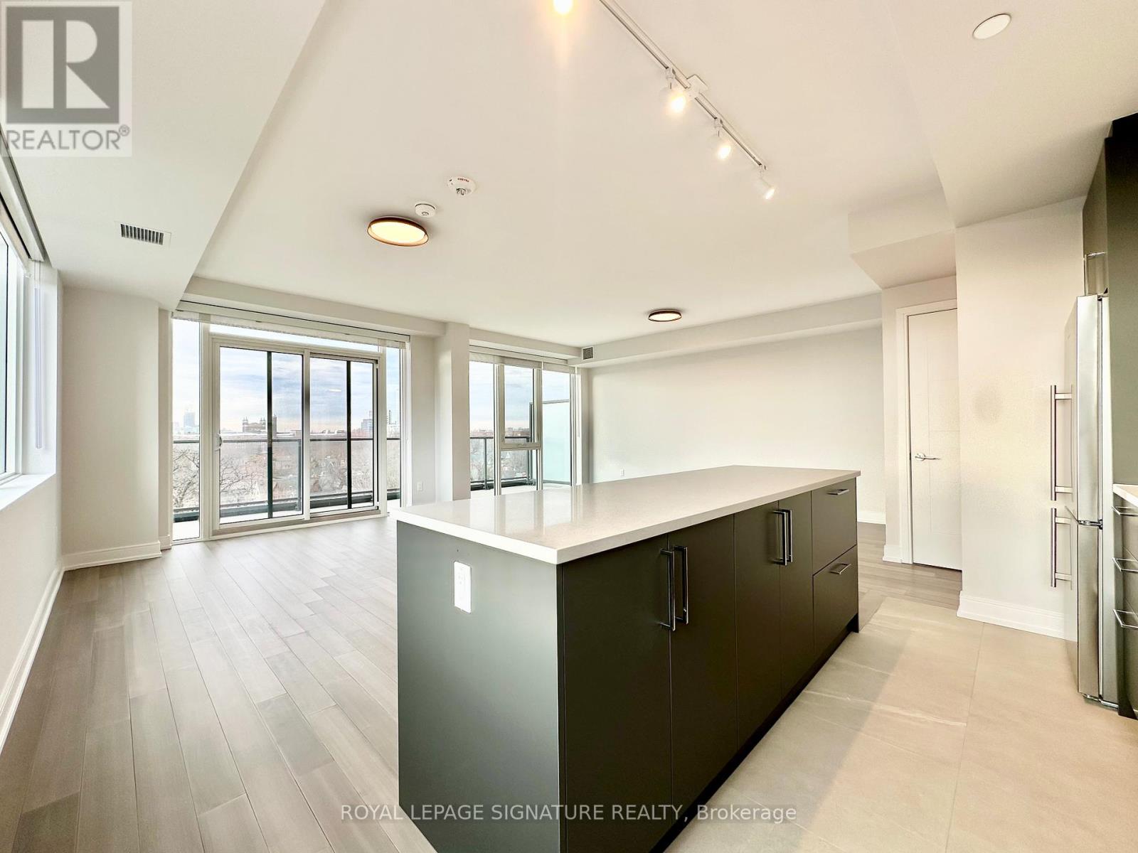 A spacious kitchen with dark cabinets and a large island.