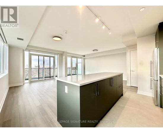 A spacious kitchen with dark cabinets and a large island.