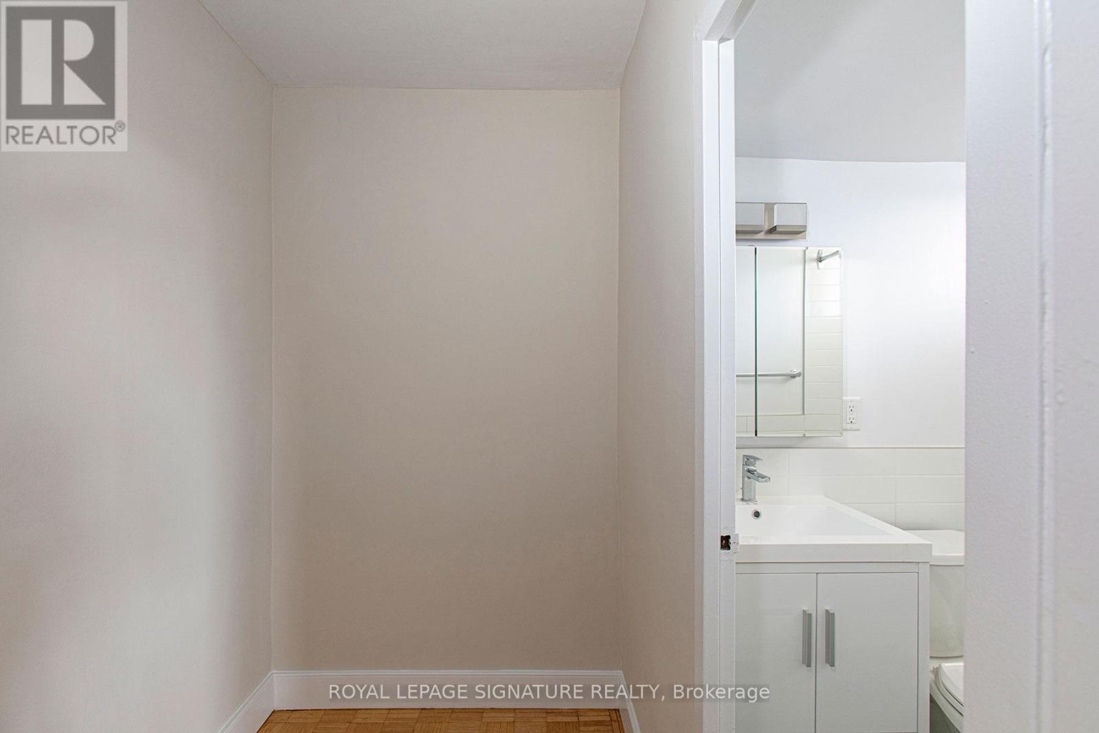 A white bathroom with a sink and mirror.