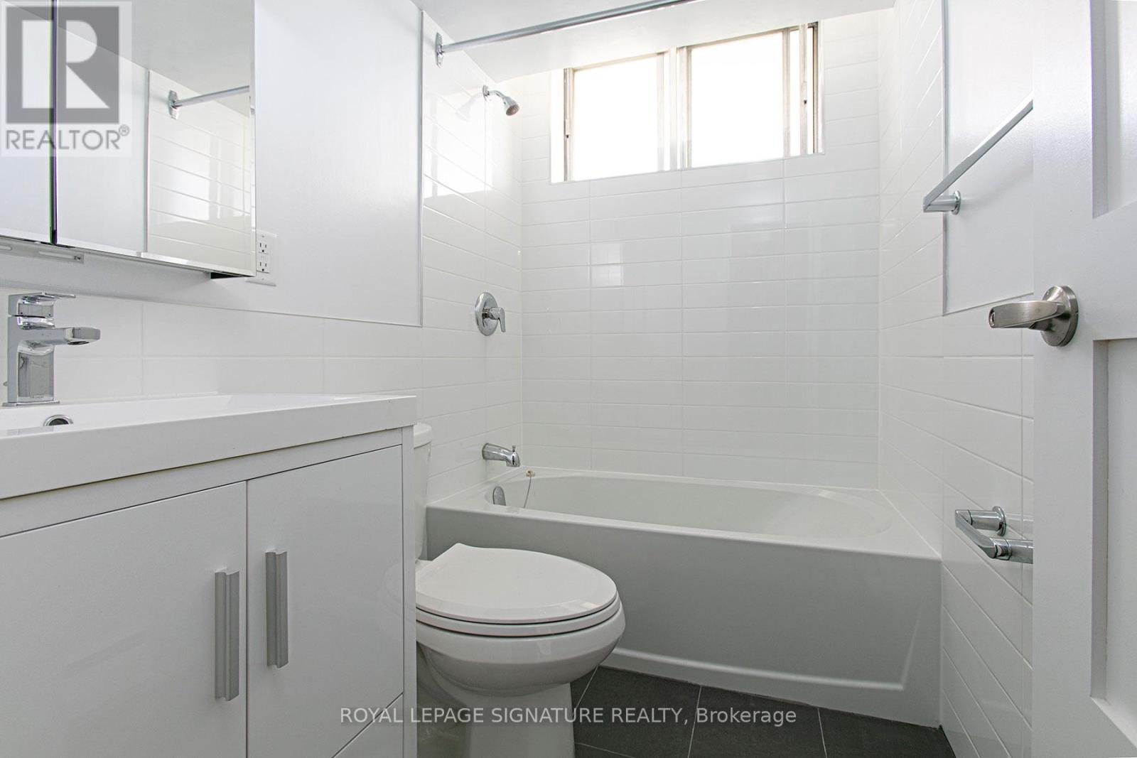 A white bathroom with a toilet, sink, and bathtub.