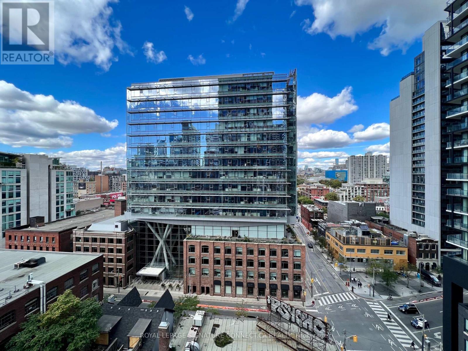 A modern glass building stands out in the cityscape.