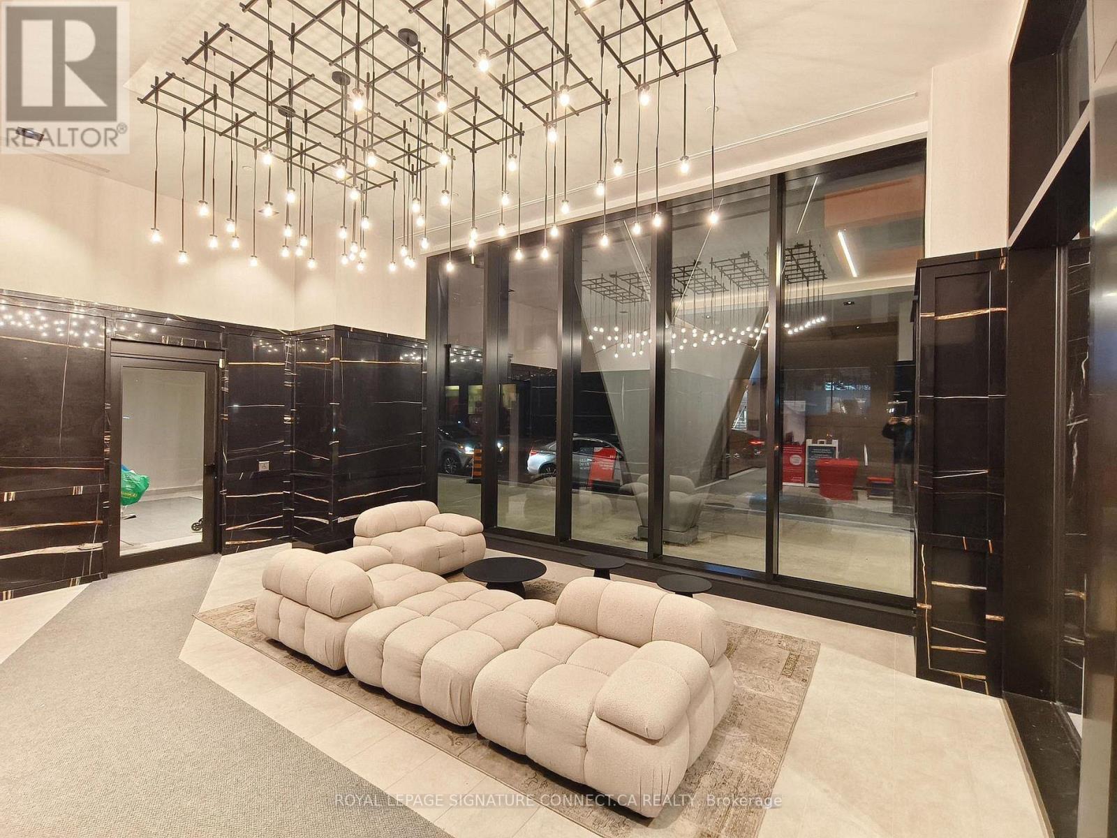 A modern living room with a large sectional sofa and a chandelier.
