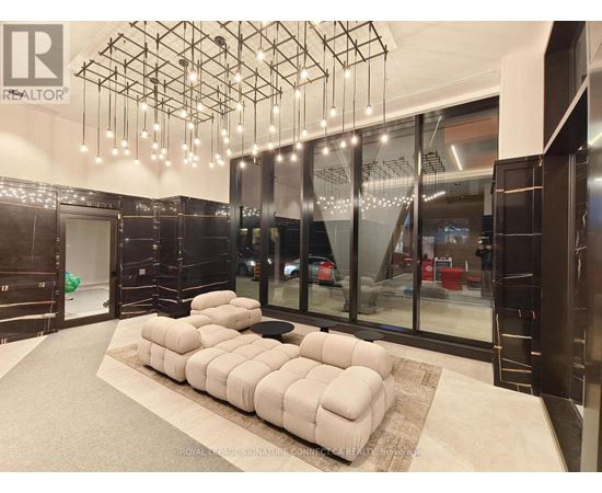 A modern living room with a large sectional sofa and a chandelier.
