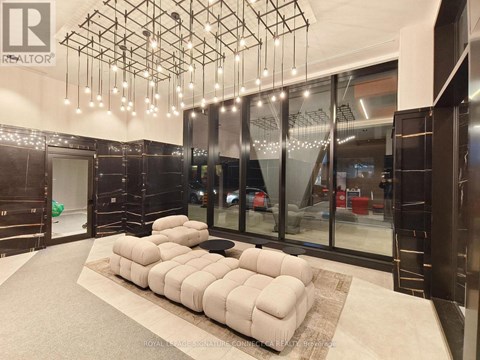 A modern living room with a large sectional sofa and a chandelier.
