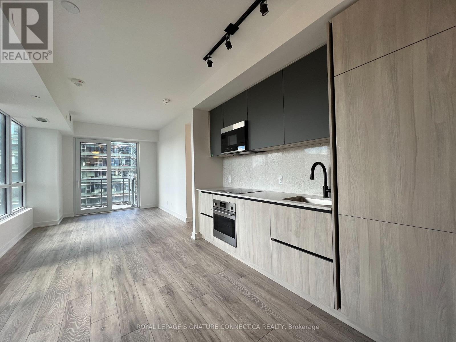 A modern kitchen with wooden flooring and a large island.