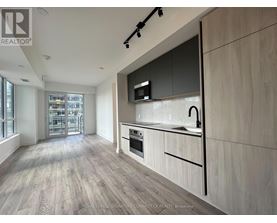 A modern kitchen with wooden flooring and a large island.