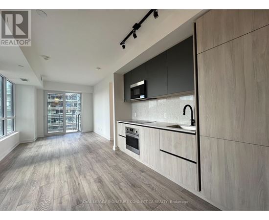 A modern kitchen with wooden flooring and a large island.