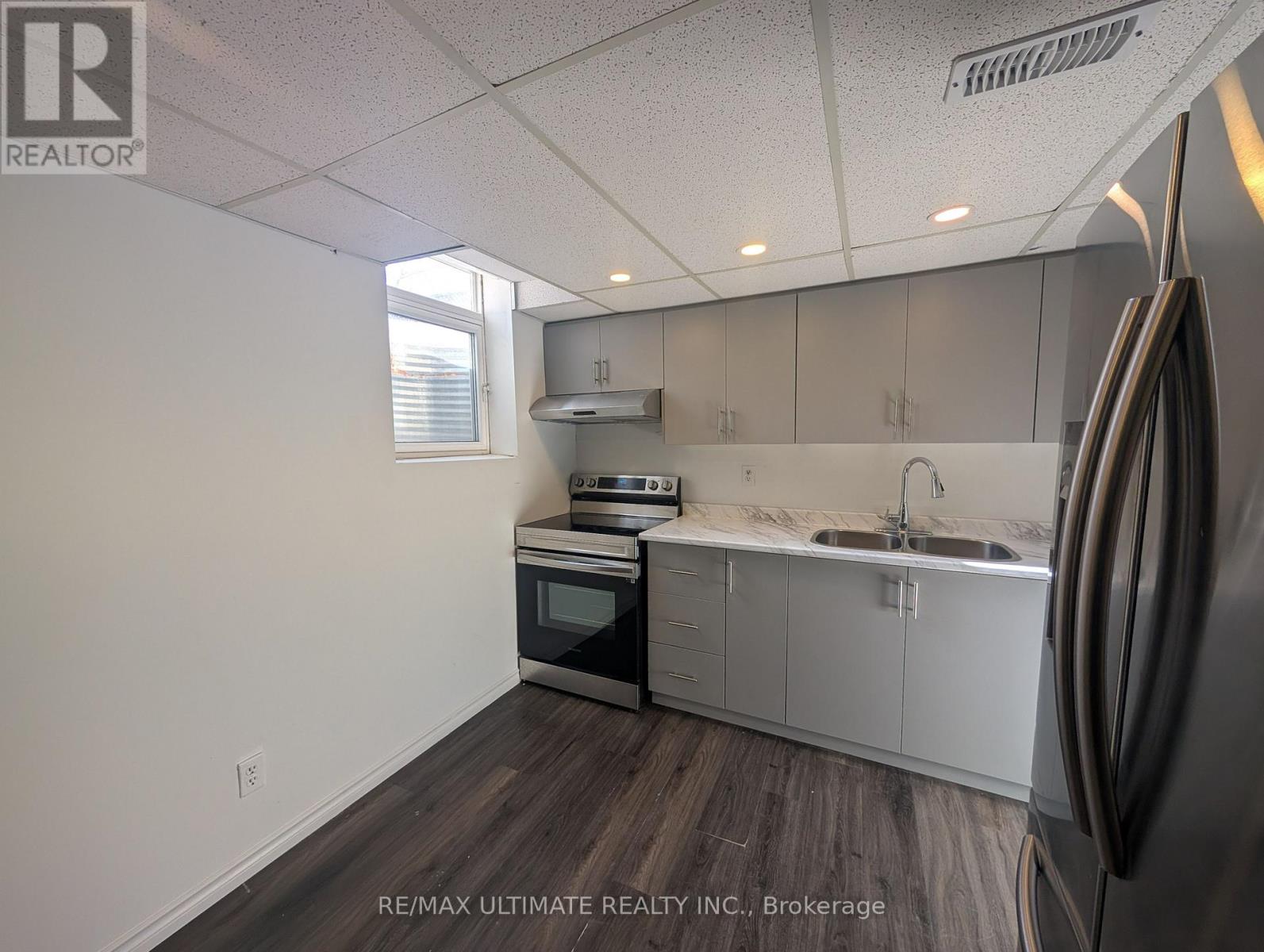 A kitchen with a refrigerator on the right side.