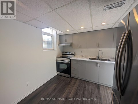 A kitchen with a refrigerator on the right side.