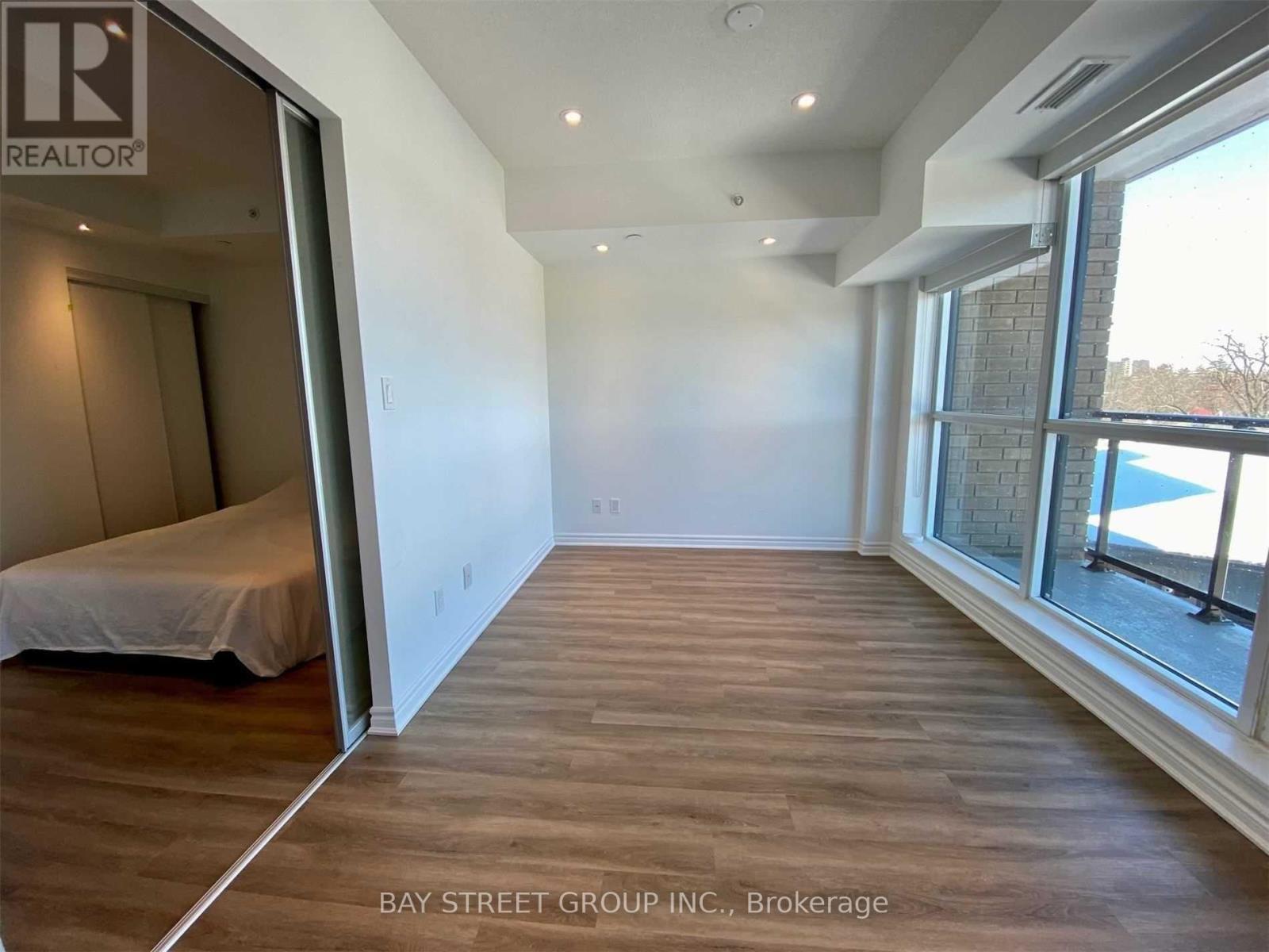A bedroom with a bed and a window overlooking a pool.