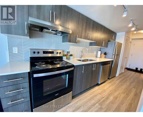 A modern kitchen with a stove top oven and a refrigerator.
