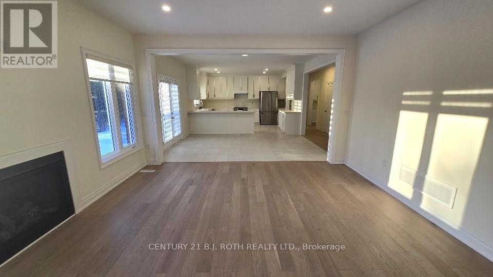 A spacious living room with wood flooring and a fireplace.
