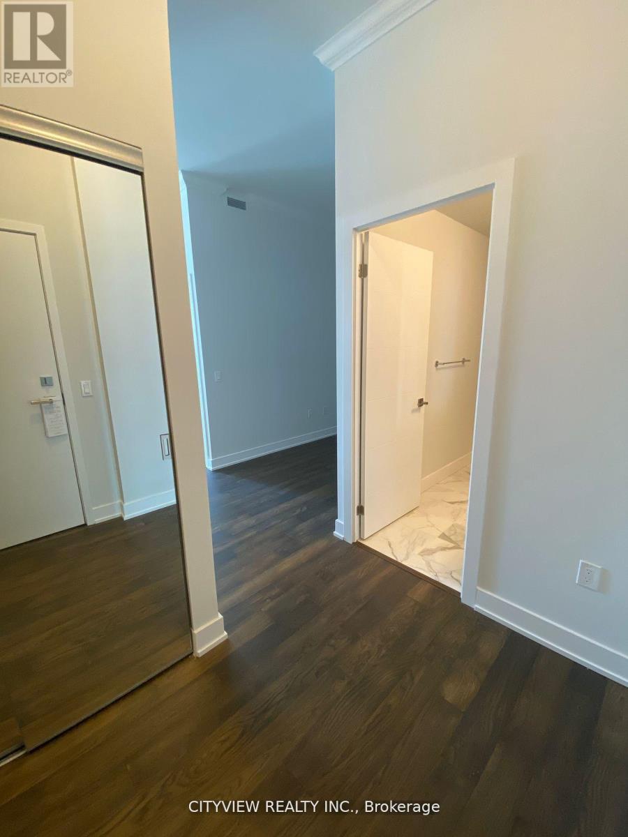 A hallway with a white door and a mirror on the wall.
