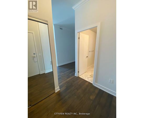 A hallway with a white door and a mirror on the wall.
