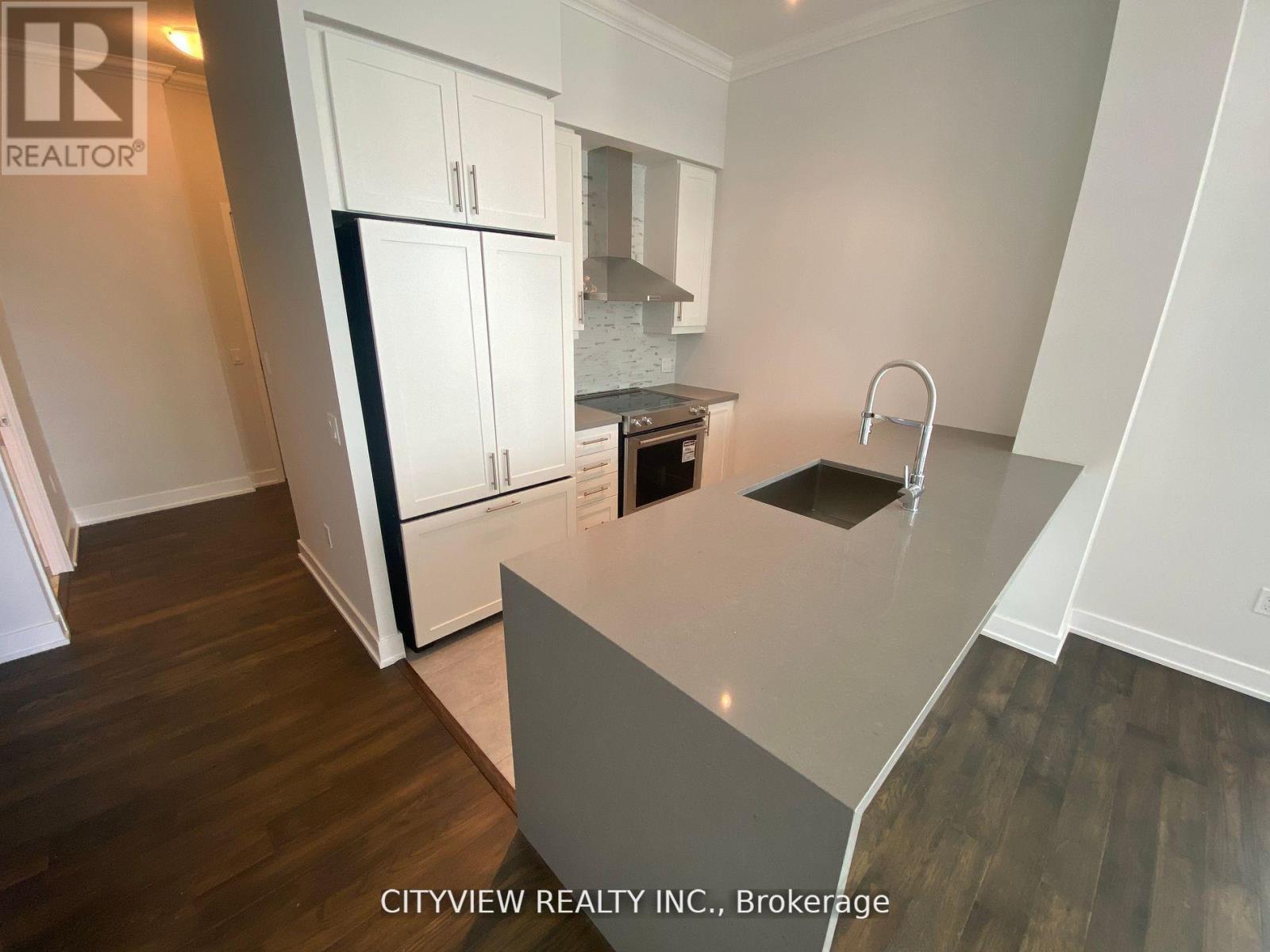 A kitchen with white cabinets and a grey island.