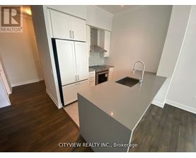 A kitchen with white cabinets and a grey island.