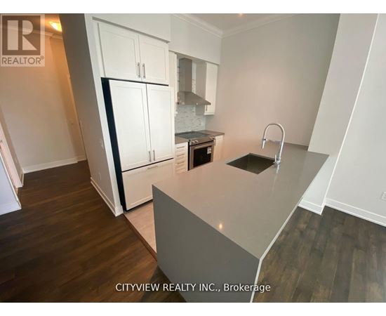 A kitchen with white cabinets and a grey island.