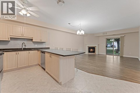 A kitchen with wooden cabinets and a black countertop.