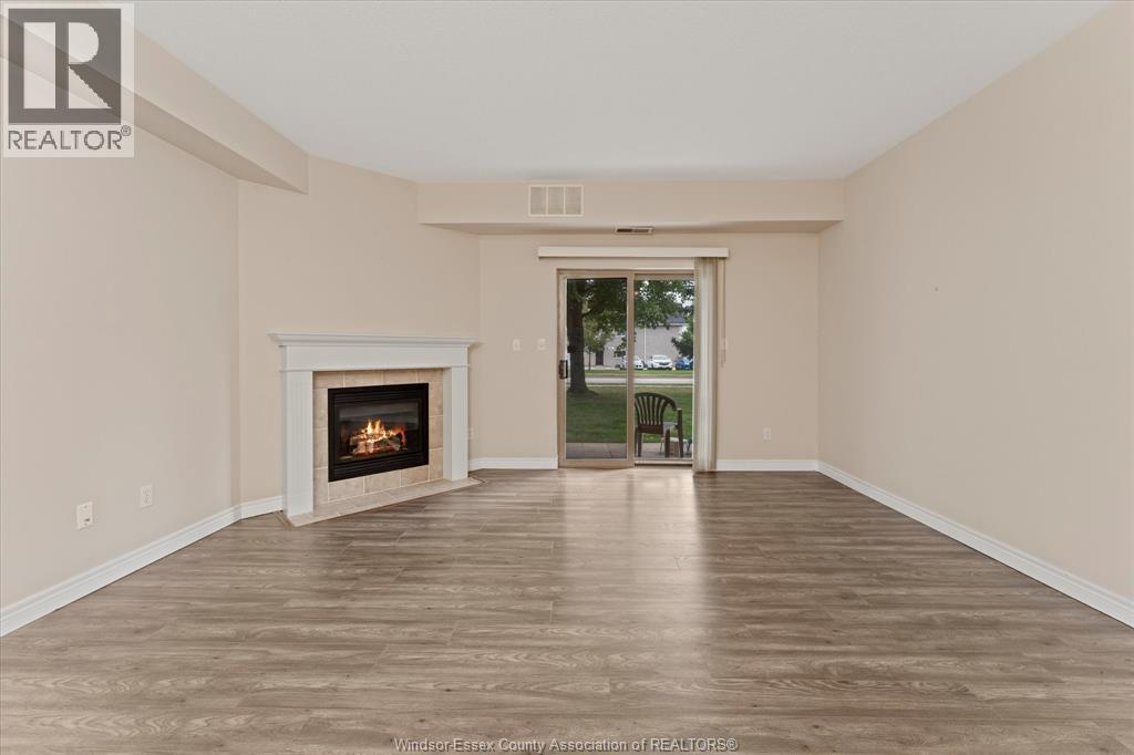 A spacious room with a fireplace and a door leading to a balcony.