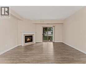 A spacious room with a fireplace and a door leading to a balcony.